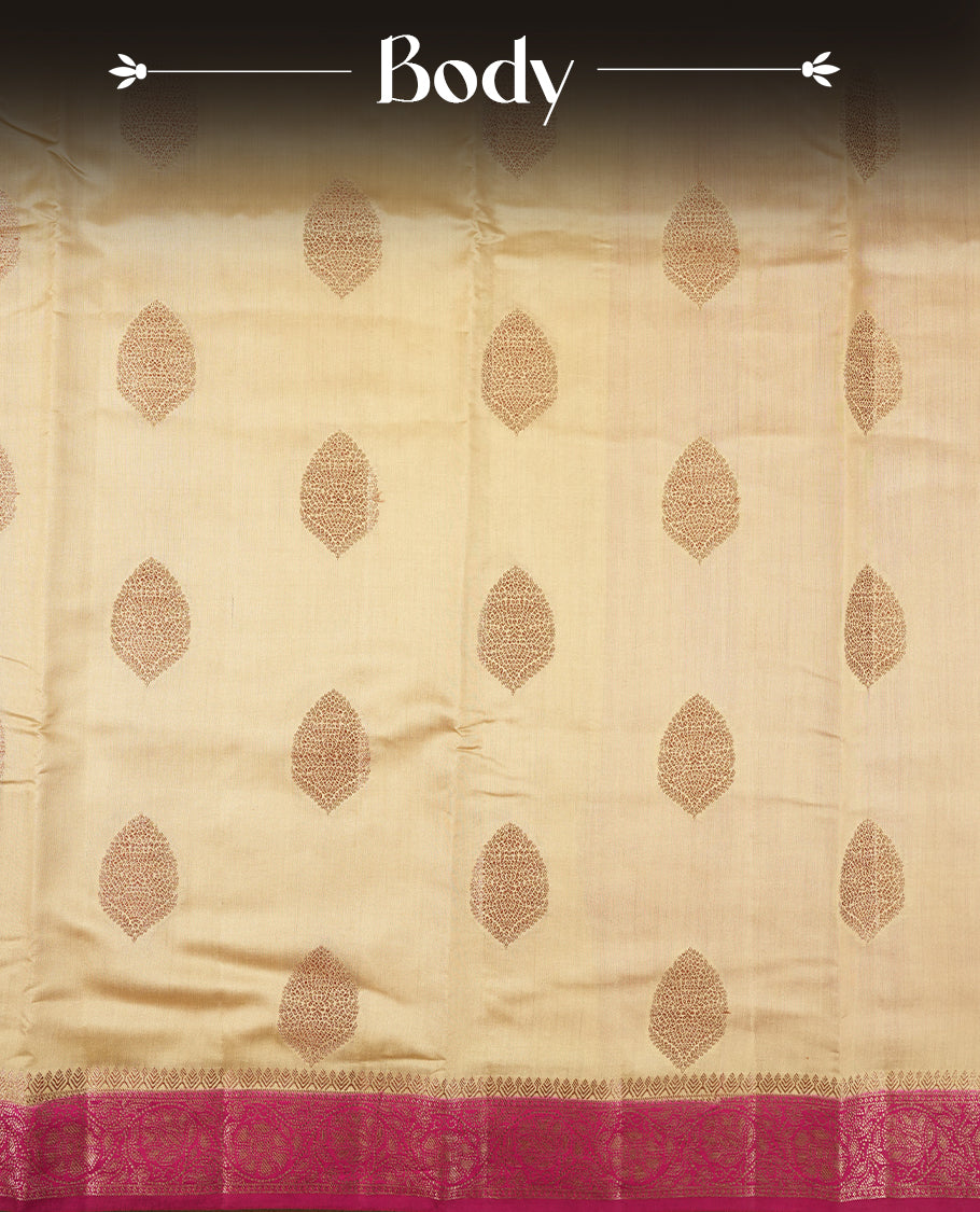 Cream Colour Banaras Soft Silk Saree with Gold and Rose Gold Zari Textured Diamond-Shaped Buttas, Simple Decorative Pallu Border, Grand Pallu with Ornate Floral and Circular Motifs in Magenta and Gold Tones, and Matching Bright Magenta Blouse.