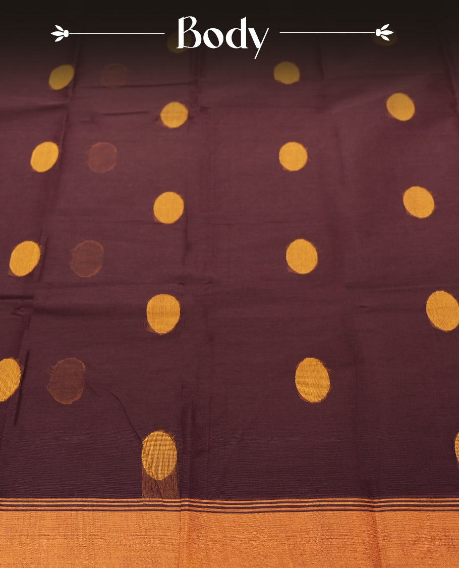 Dark Brown colour Silk Cotton Saree with Mustard Orange Circular Buttas on the Body, Contrasting Antique Gold Zari Pallu Featuring Intricate Floral and Geometric Motifs with Temple-Style Borders, Paired with a Coordinated Blouse Piece