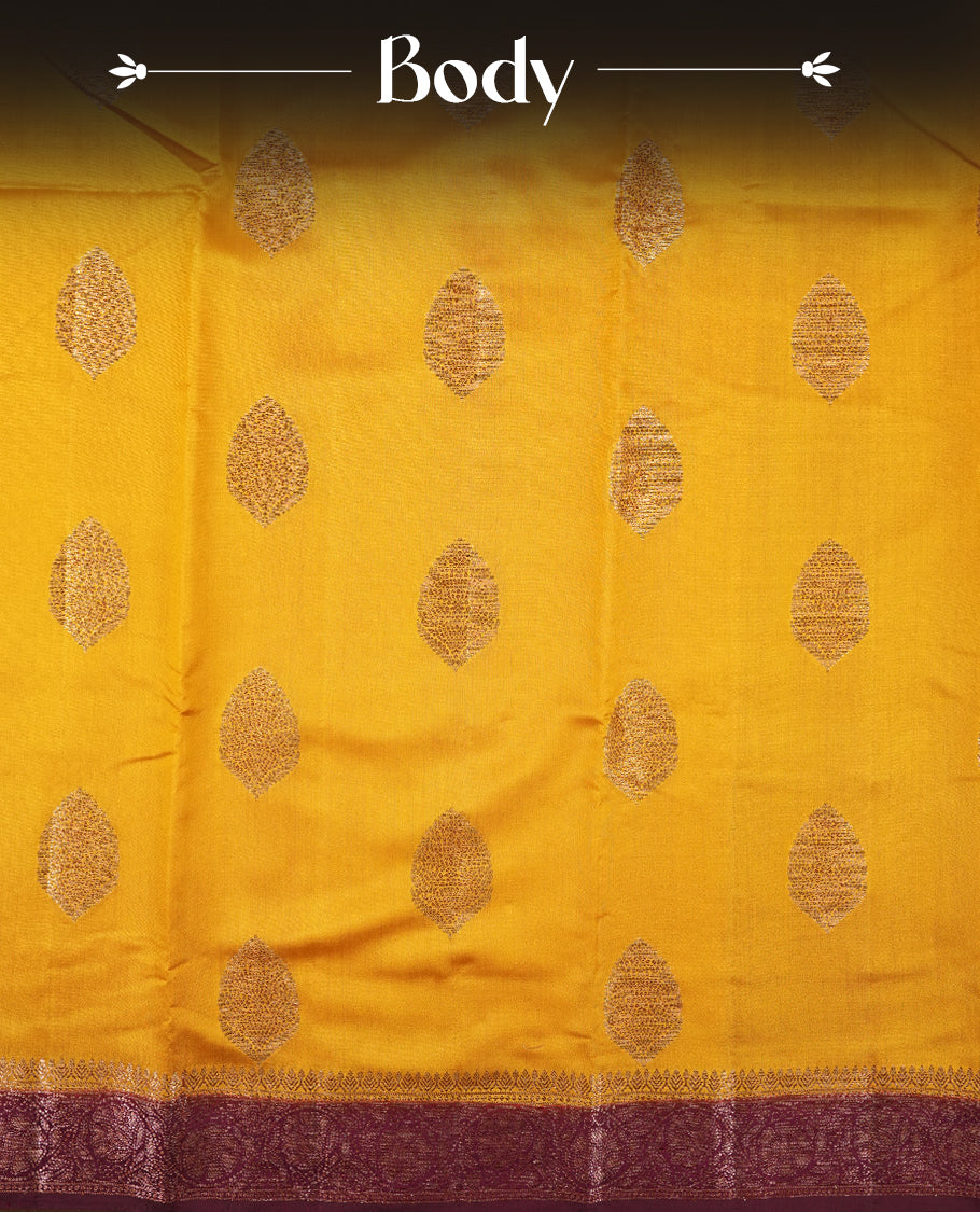 Golden Yellow Colour Banaras Soft Silk Saree with Gold Zari Oval Textured Buttas, Simple Decorative Pallu Border, Grand Pallu with Ornate Circular and Foliate Motifs in Maroon and Gold Tones, and Matching Deep Maroon Blouse.