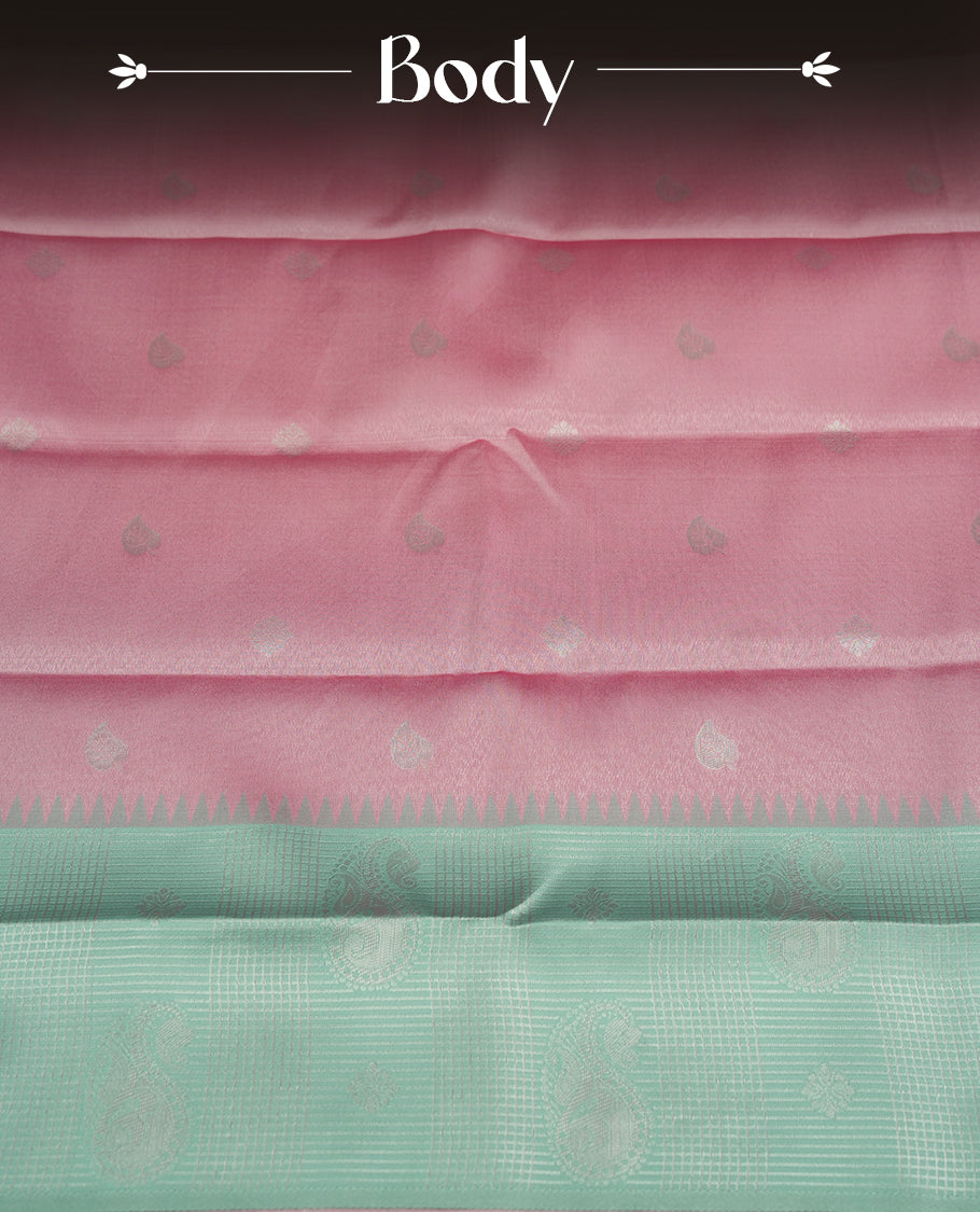 Light pink colour semi silk saree adorned with silver zari designs on the body, complemented by a contrasting light green and silver border and pallu, and paired with a matching blouse piece