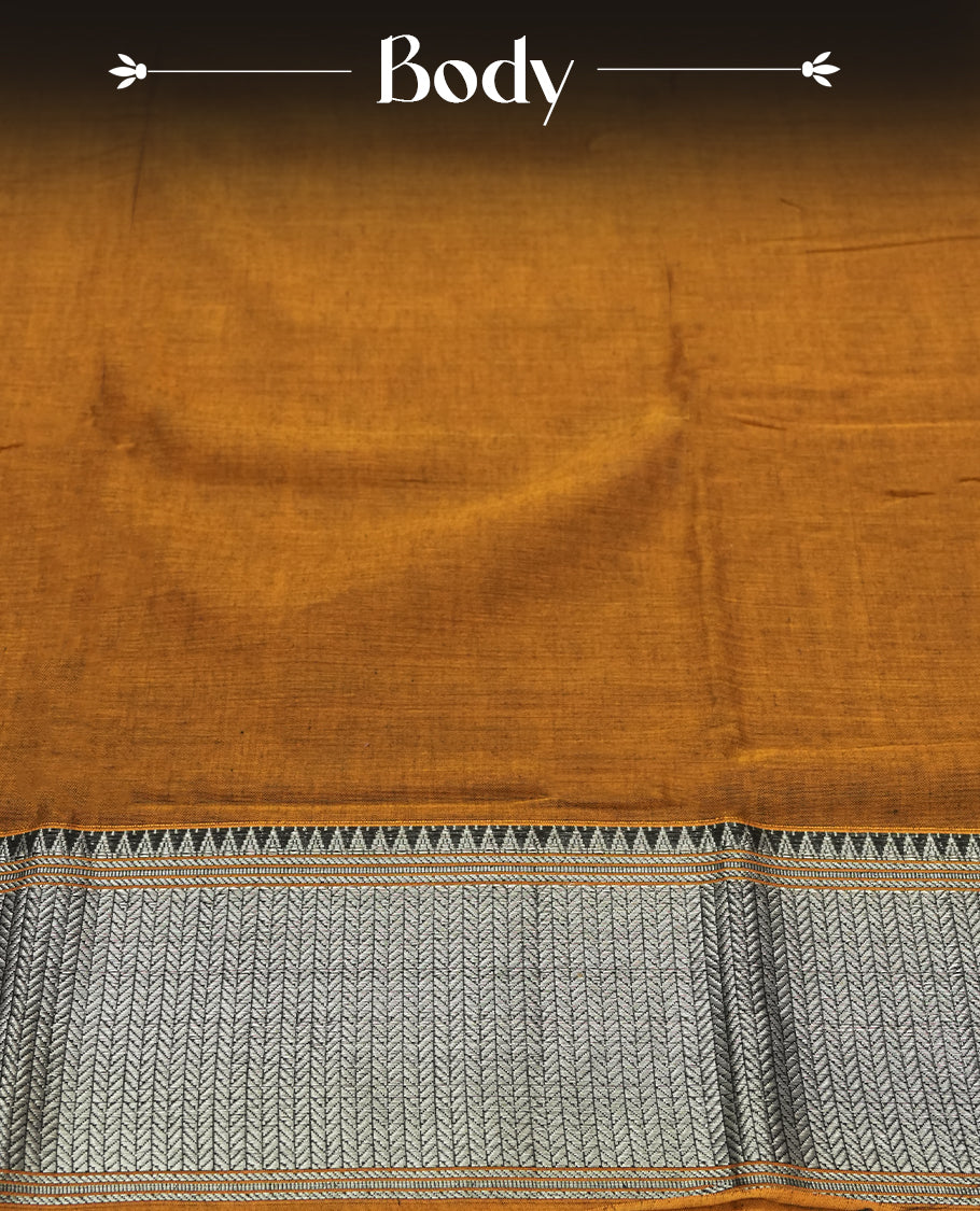 Dark mustard colour Narayanapattu cotton saree featuring a self coloured body, yellow coloured with silver zari pattern border and cream colour pallu, pairing a matching blouse piece.
