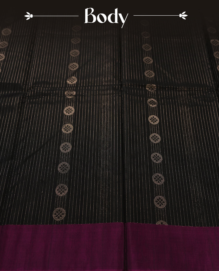 Black colour pure Handloom cotton saree featuring delicate rose gold zari stripes and motifs, paired with a rich purple border, perfect for graceful occasions & Comes with matching blouse.
