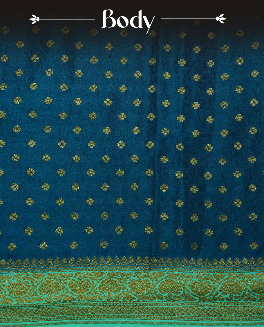 Dark Blue colour pure Banarasi georgette saree featuring gold zari Flower Motifs all over the body, complemented by an contrast sky blue dye colour with gold zari Floral Kodi Worked border and pallu, with matching blouse.