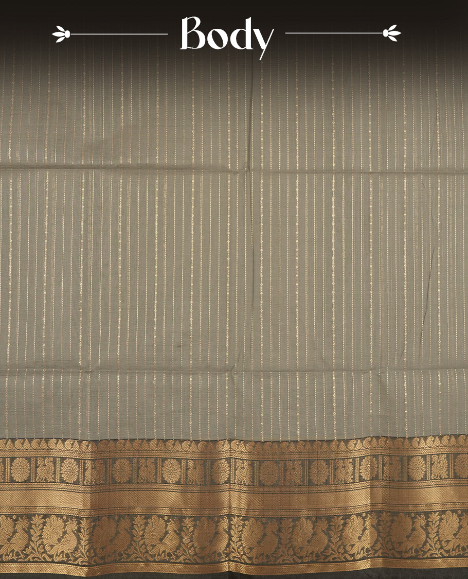 Grey colour Chettinad cotton saree adorned with subtle golden zari lines on the body, The rich ash colour border features intricate peacock and floral motifs in golden zari & Comes with a matching blouse piece.