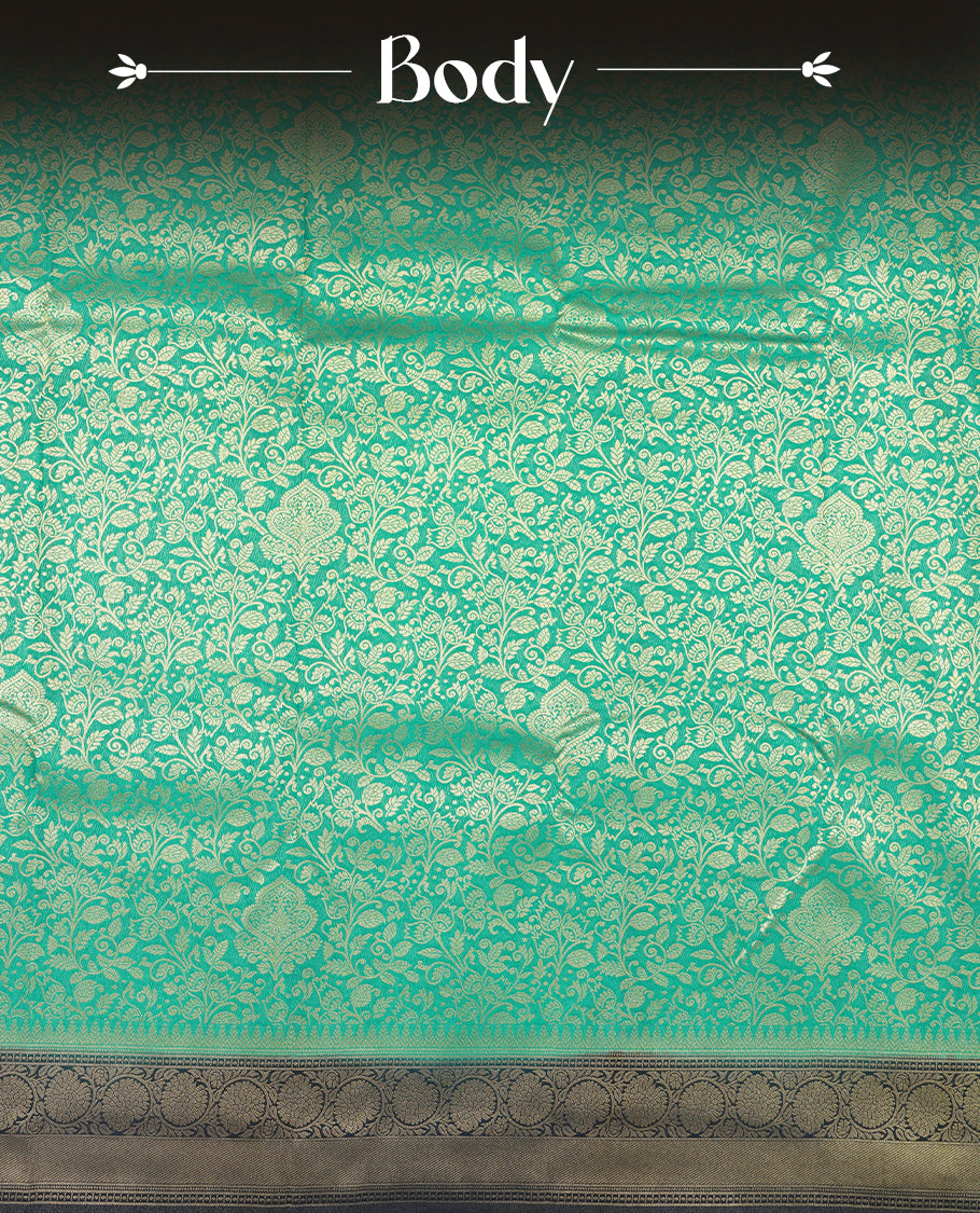 Aqua green colour semi silk brocade saree featuring intricate Gold Floral kodi patterns across the body, complemented by a contract dark blue colour woven border and pallu, paired with a matching blouse.