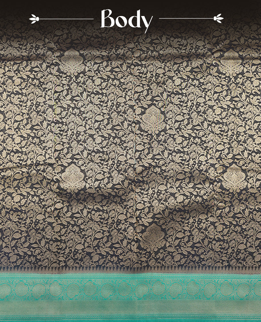 Dark Blue colour semi silk brocade saree featuring intricate Gold Floarl kodi patterns across the body, complemented by a contrast rich Aqua green colour woven border and pallu, paired with a matching blouse.