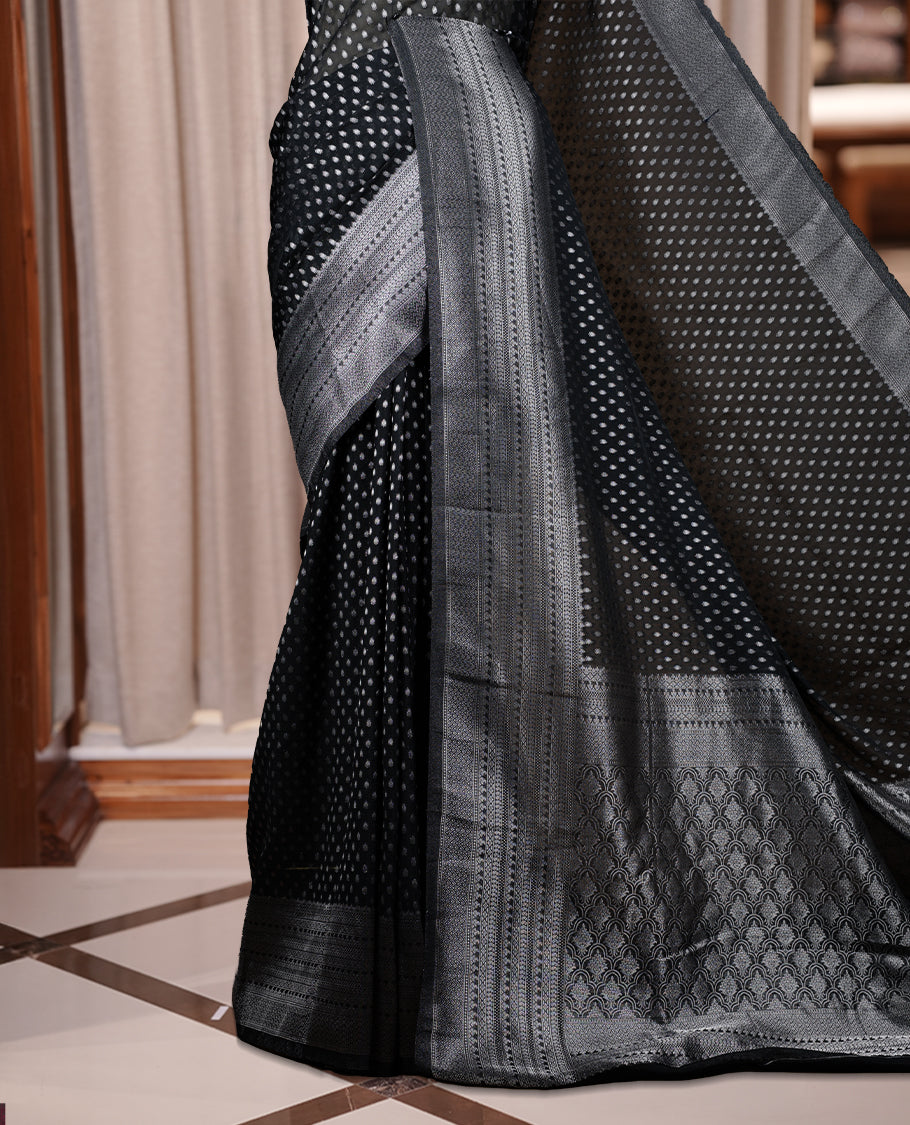 Black colour Banarasi silk saree featuring intricate zari weaving and a soft silk texture, Adorned with silver motifs on the body, complemented by a rich Banarasi border and pallu & Comes with a matching blouse.