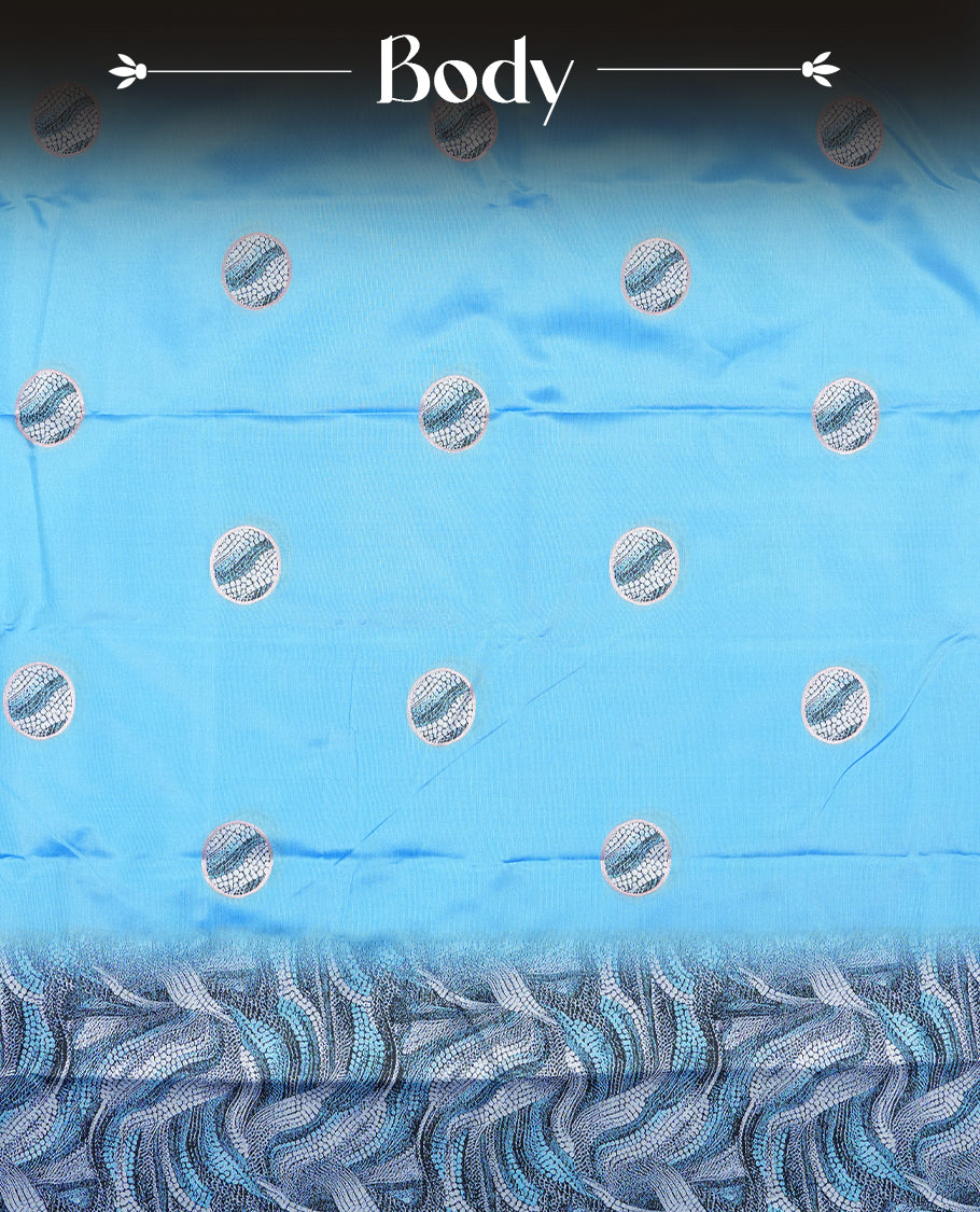 Sky blue semi silk saree featuring elegant circular motifs on the body, complemented by a striking pallu adorned with intricate wavy white thread patterns with golden border, and paired with a matching blouse