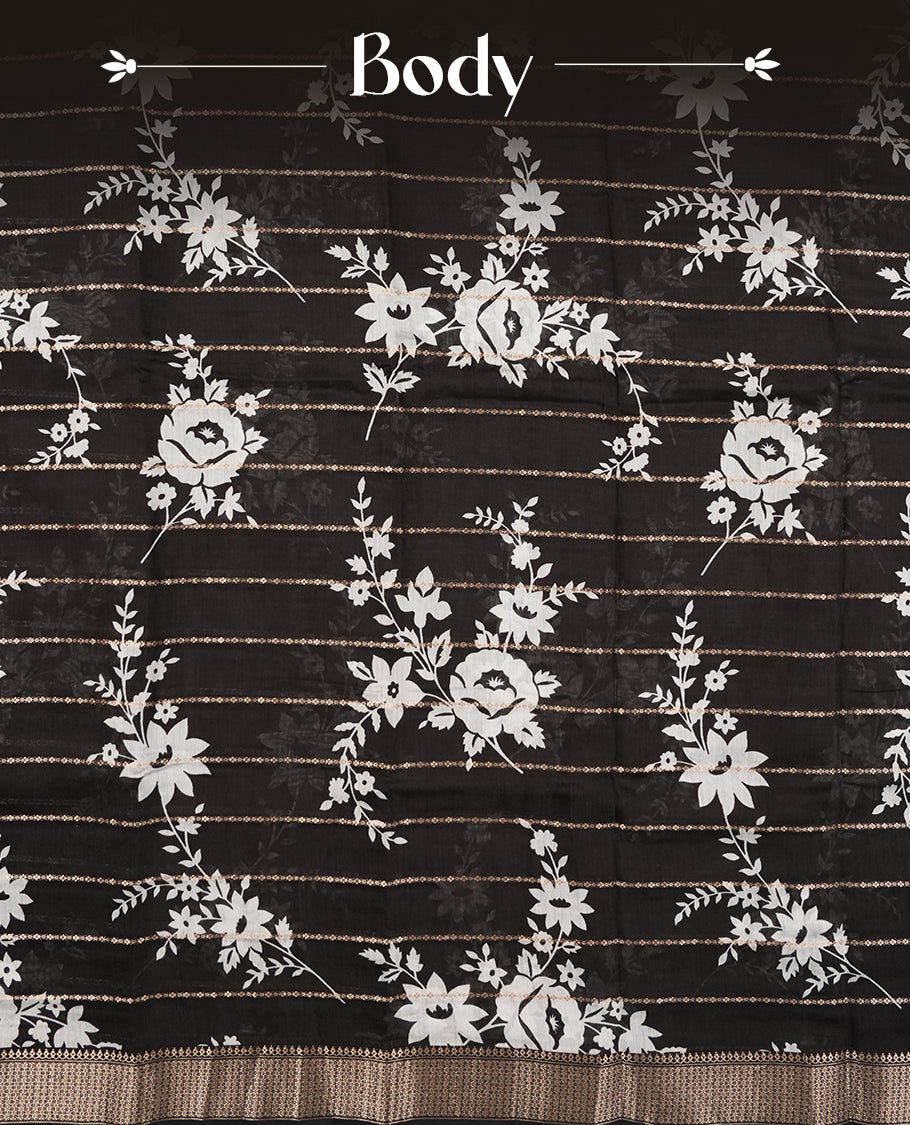 Black colour chanderi silk saree with gold zari strip pattern & white Floral print pattern On body, compilmented by self colour border with antique zari pattern and a matching blouse.