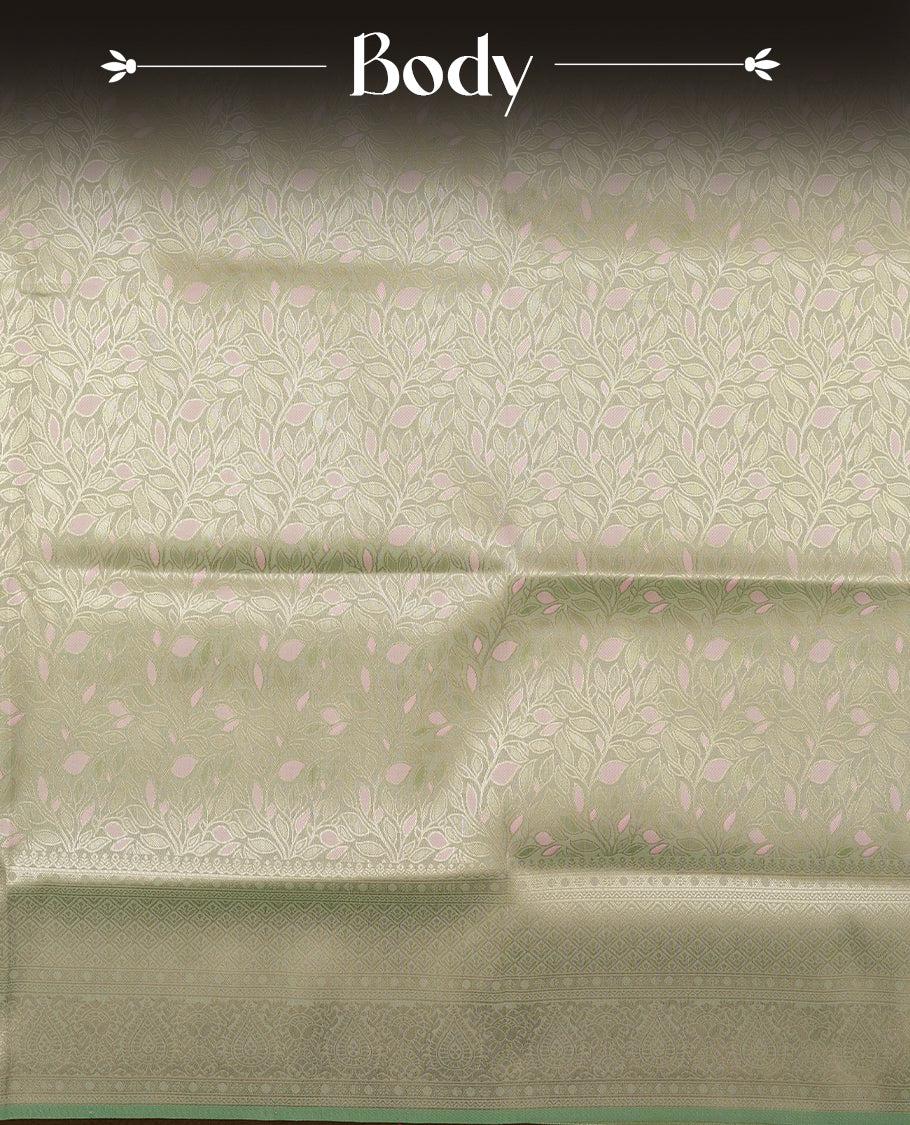 Pastel green colour semi soft silk saree featuring an all-over woven leaf pattern in gold colour, finished with a matching border adorned with detailed paisley and floral motifs, and a matching blouse piece.