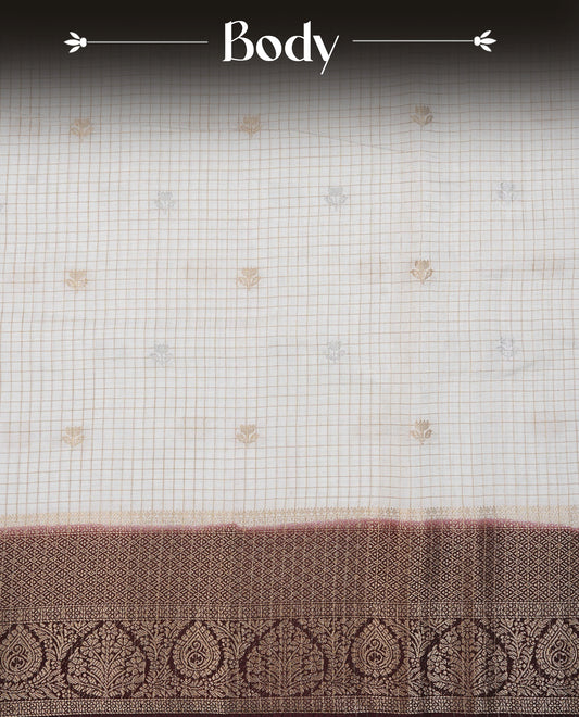 Semi Banaras Tussar Saree Featuring Gold Zari Check With Floral Pattern On Body , Chocolate Brown Colour  With Gold Zari Border , Paired With  A Matching Blouse Piece.