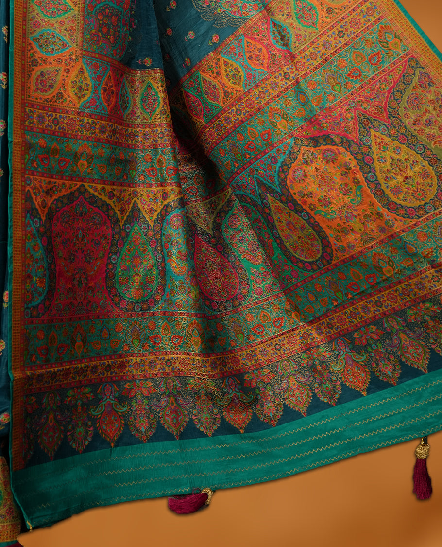 Dark teal blue colour Pashmina silk saree densely woven with intricate multicolour floral motifs across the body, framed by an opulent arabesque border and grand storytelling pallu, paired with a matching woven border blouse piece