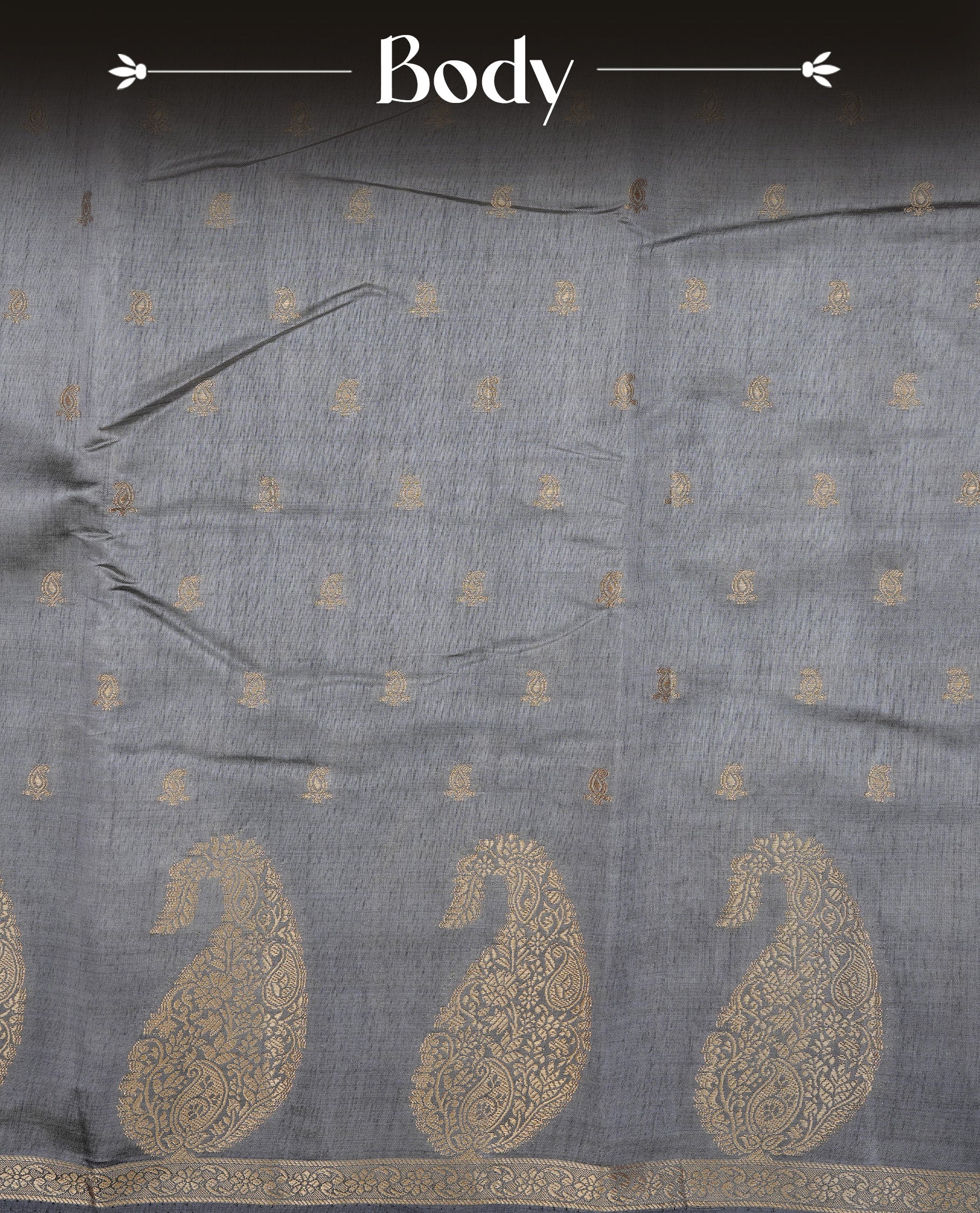 Grey colour semi tussar silk saree featuring small gold zari mango motifs across the body, enhanced with a self colour border showcasing elegant gold zari mango patterns. Paired with a matching blouse piece.