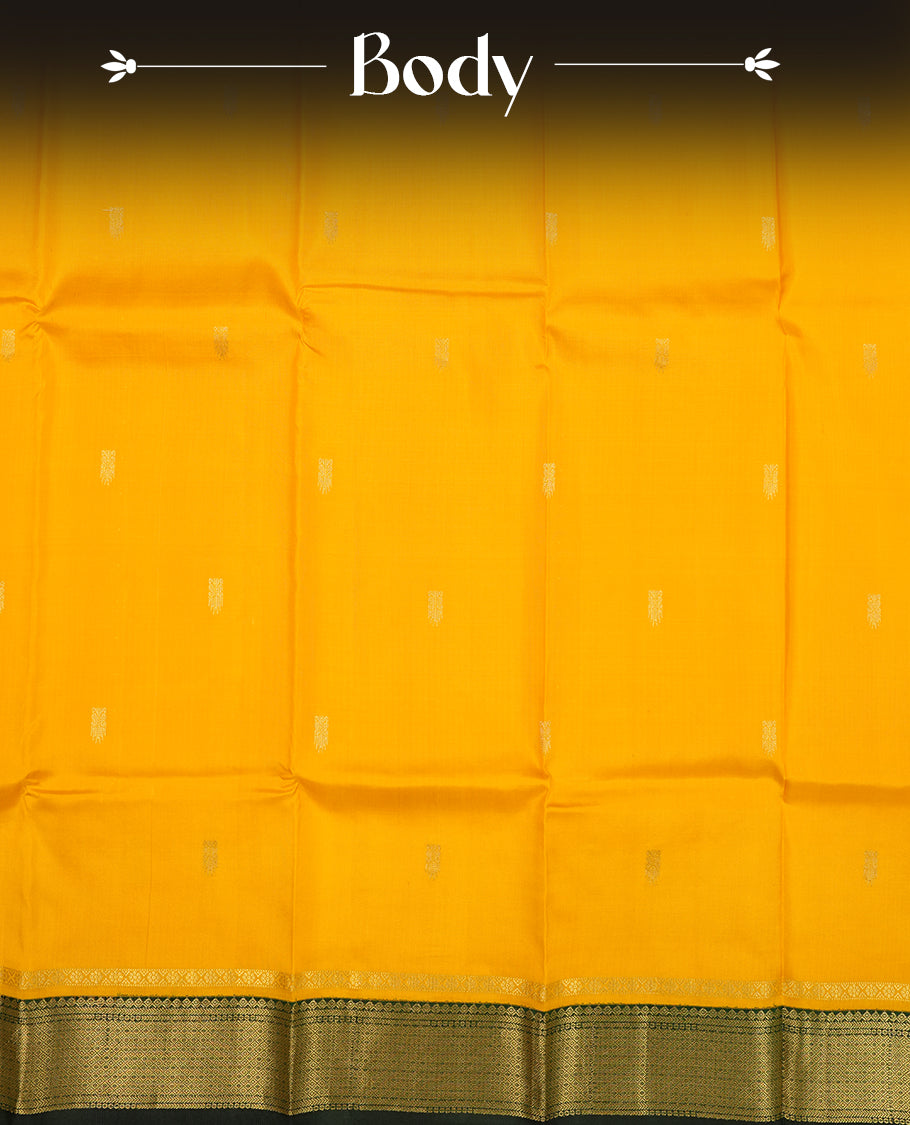 Mustard Yellow colour Vasundhara silk saree adorned with all-over gold motifs on the body, complemented by a contrast dark green colour with gold mayil motifs border and paired with a matching blouse piece.