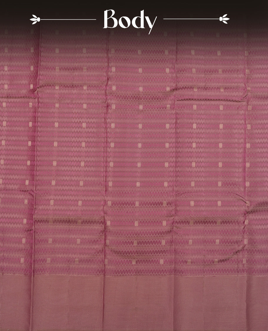 Dusty purple colour Vasundhara silk saree adorned with all-over zigzag motifs on the body, complemented by a  self colour with gold line pattern border and paired with a matching blouse piece.