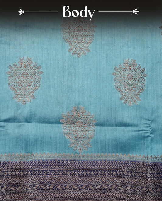 Pastel Aqua Colour Tussar Silk saree with elegant antique zari floral motifs On Body, a contrasting navy blue zari border, a rich zari pallu, Paired With a matching  blouse piece.