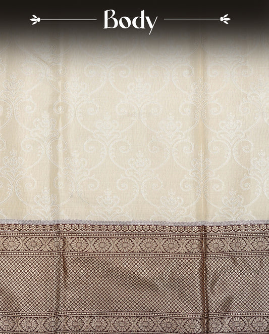 Beige Colour Tissue Silk Saree featuring an elegant Silver zari woven body, a richly woven Gold zari pallu, complemented by a Dark Brown With Gold zari border and paired with a Matching  blouse piece.