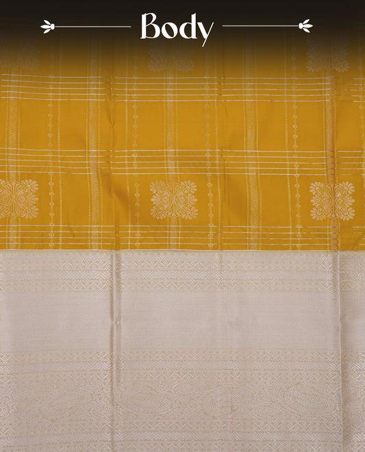 Mustard yellow colour soft silk saree featuring gold zari checks with floral mottifs on body, contrast cream colour gold zari traditional border, grand pallu comes with matching blouse piece.
