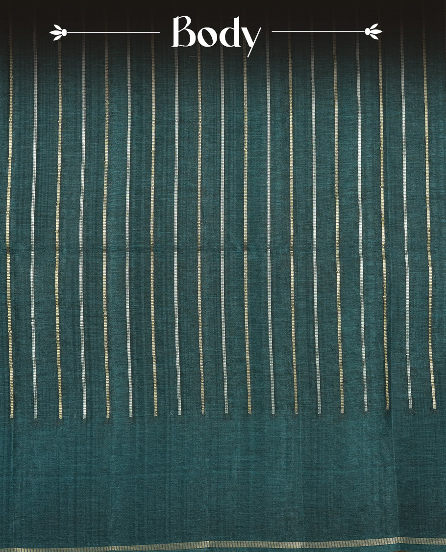 Teal colour semi tussar silk saree highlights gold and silver zari stripes across body,  border, pallu and paired with matching blouse piece.