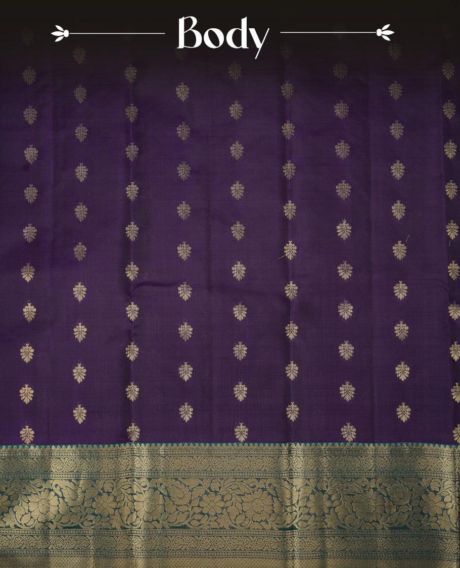 Purple colour soft silk saree featuring gold zari floral motifs on the body, complemented by a contrast green traditional zari floral kodi border and pallu, paired with a matching blouse piece.