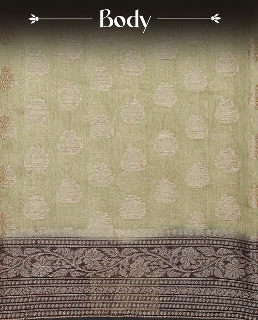 Pastel Olive Colour Tussar Silk saree with antique zari butta motifs On Body, a Brown floral zari border, a rich zari pallu, and a matching blouse piece.