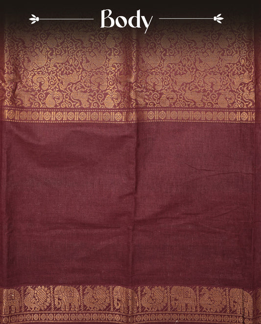 Maroon Colour Sungudi Cotton Saree with gold zari elephant & Peacock motifs on the body, a self zari border, and a rich gold zari pallu. Paired with a Contrast Green colour blouse Piece featuring a gold zari border.