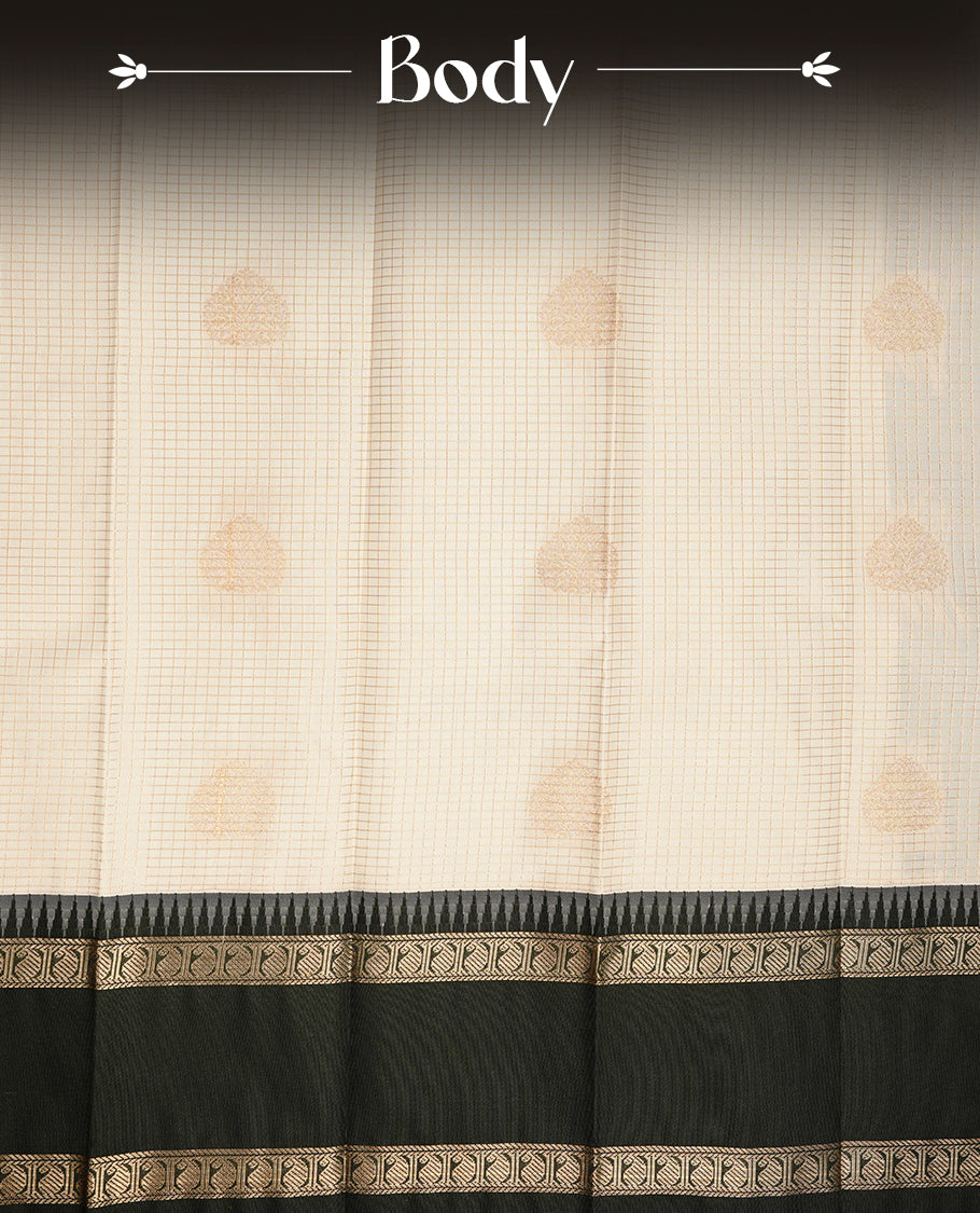 Cream coloured soft silk saree featuring gold zari stripes and motifs across the body, enhanced with a contrast Deep green border and pallu, paired with a matching contrast blouse piece