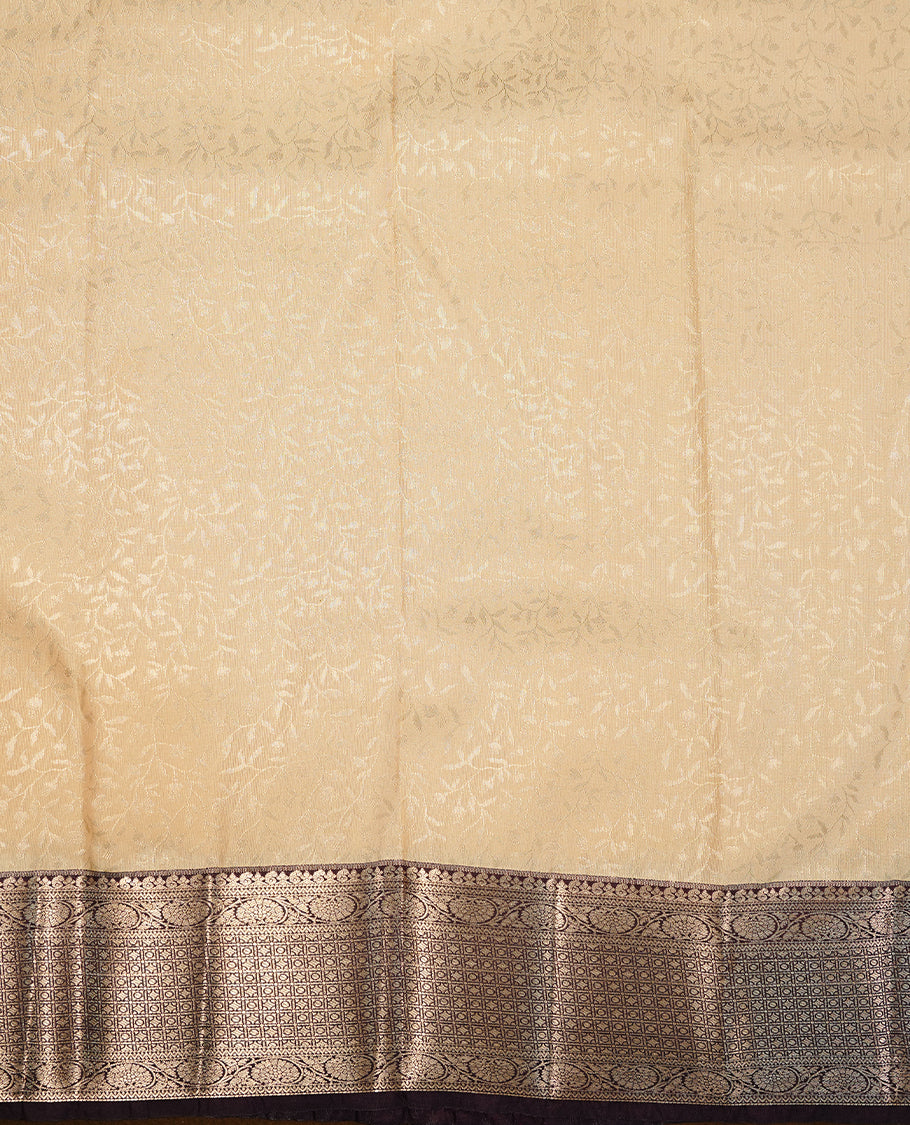 Cream colour semi wedding saree featuring gold zari floral kode pattern on body, complemented by contrast burgundy with traditional border, paired with matching blouse piece.