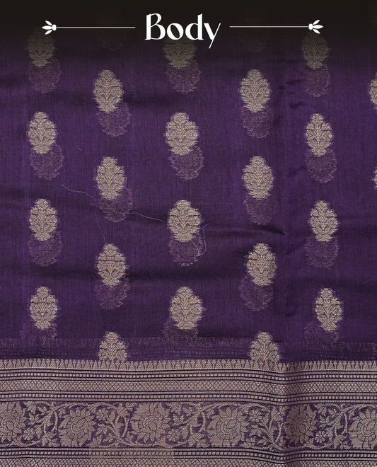 Royal Purple colour Tussar Silk saree featuring antique zari butta motifs on the body, enhanced with a self-coloured floral zari border and pallu, paired with a matching blouse piece.