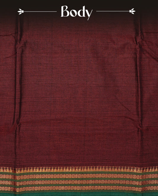 Maroon colour Narayanapattu cotton saree with a plain body, complemented by a Green colour with Gold Zari border & contrast pallu, paired with a matching blouse piece