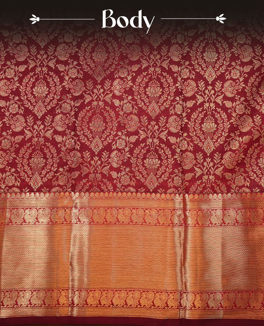 Maroon colour kancheepuram silk saree featuring gold zari floral kodi pattern on body, complemented by self colour with traditional border, paired with matching blouse piece.