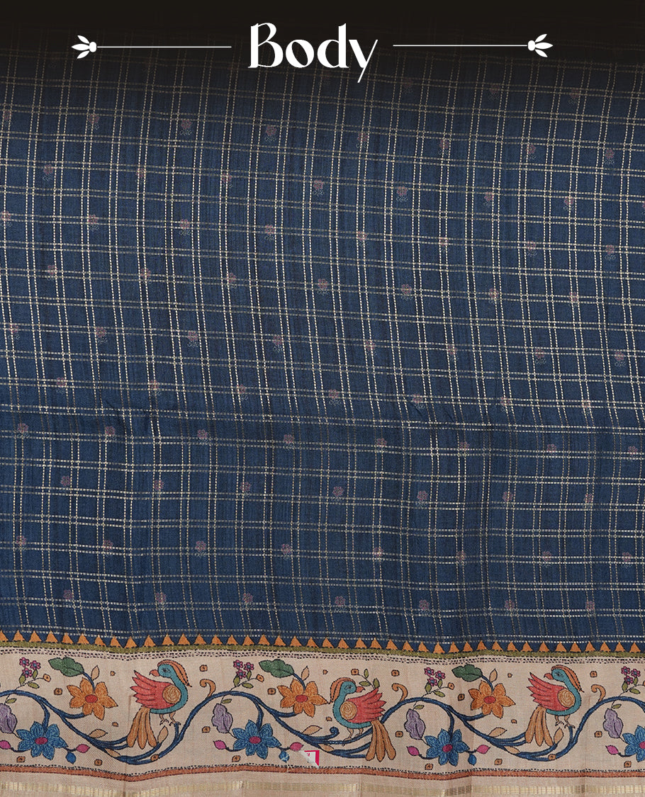 Dark blue colour semi tusser silk saree featuring gold zari check pattern with floral butti motifs, with contrast floral kodi & bird pattern and paired with matching blouse.