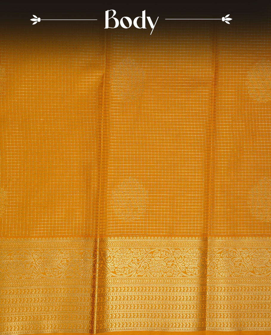 Mustard coloured soft silk saree featuring gold zari stripes and motifs across the body, enhanced with a Self colour border and pallu, paired with a matching contrast blouse piece.