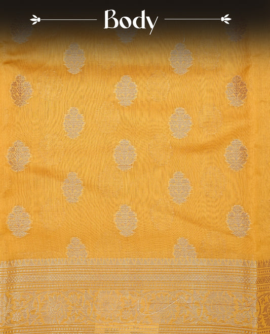 Mustard Yellow colour Tussar Silk saree featuring antique zari butta motifs on the body, enhanced with a self-coloured floral zari border and  pallu, paired with a matching blouse piece.