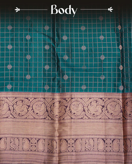 Teal Blue Colour Traditional Kancheepuram Silk Saree with Gold Zari Checks and Delicate Floral Buttas on the Body, Enhanced with a Contrast Purple Colour with Grand Gold Zari Traditional Border and Pallu, Paired with a Matching Blouse Piece.