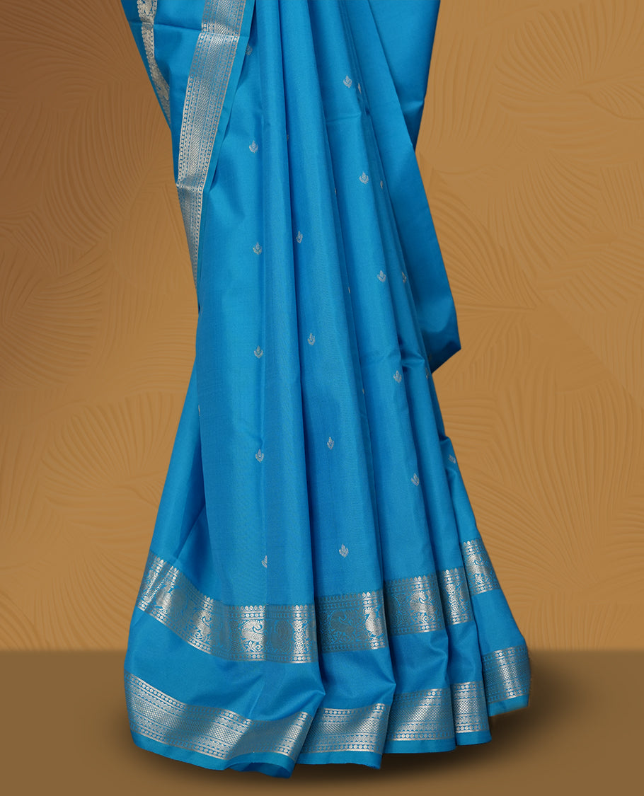 Sky blue colour soft silk saree with delicate silver zari buttas, complemented by a shimmering silver border and pallu & Paired with a matching blouse.