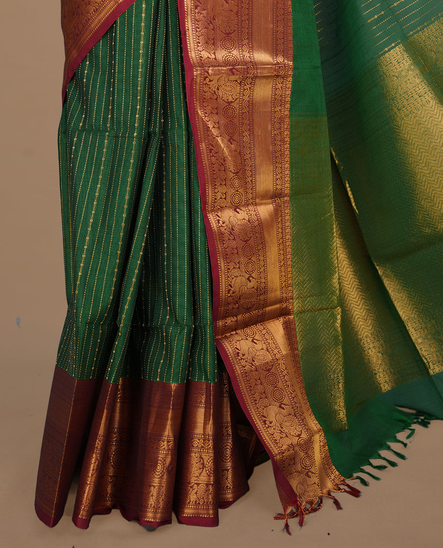 Green colour chettinad saree featuring gold zari stripes on body, complemented by contrast maroon colour with traditional border, paired with matching blouse piece.