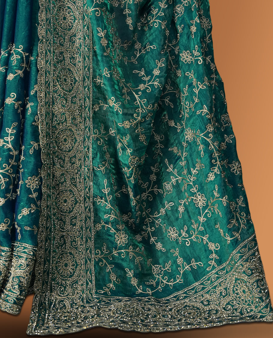 Sky blue colour velvet chiffon designer saree in elegant two tone shades, featuring light gold zari, kodi work with handwoven style thread aari & dori embroidery work, Swarovski stone work and all over motifs, comes with matching blouse.