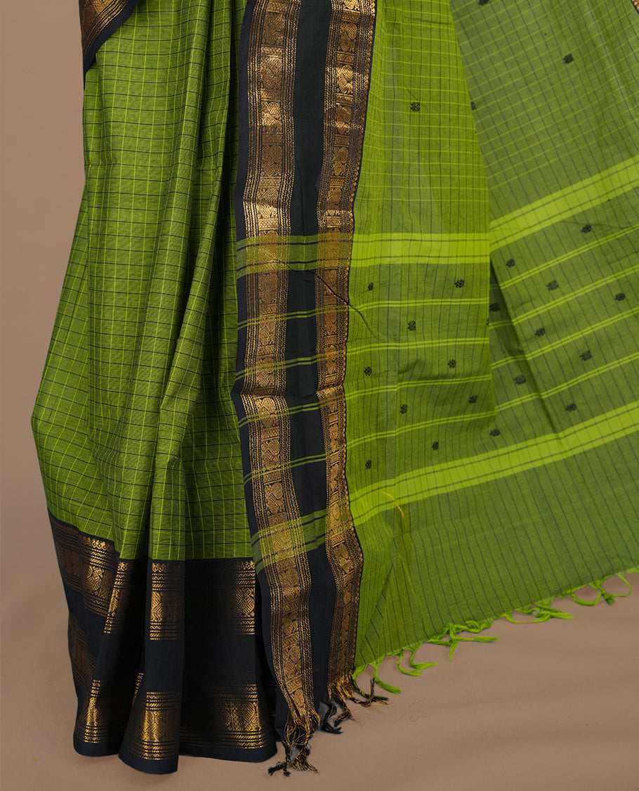 Green colour chettinad cotton saree featuring check pattern on body, complemented by contrast black with gold zari border, paired with matching blouse piece.