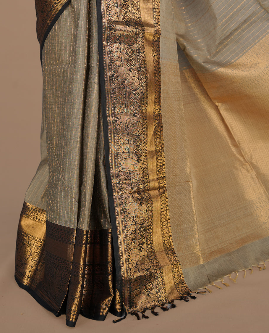 Grey colour chettinad cotton saree featuring gold zari stripes on body, complemented by contrast black colour with gold zari border, paired with matching blouse piece.