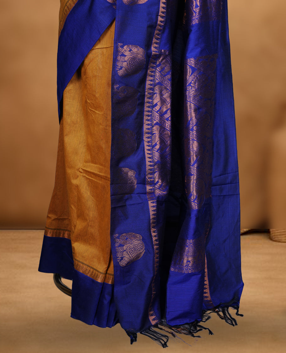 Mustard colour mixed Kalyani cotton saree with subtle zari motifs, royal blue zari border and elephant motif pallu, paired with a matching blouse.