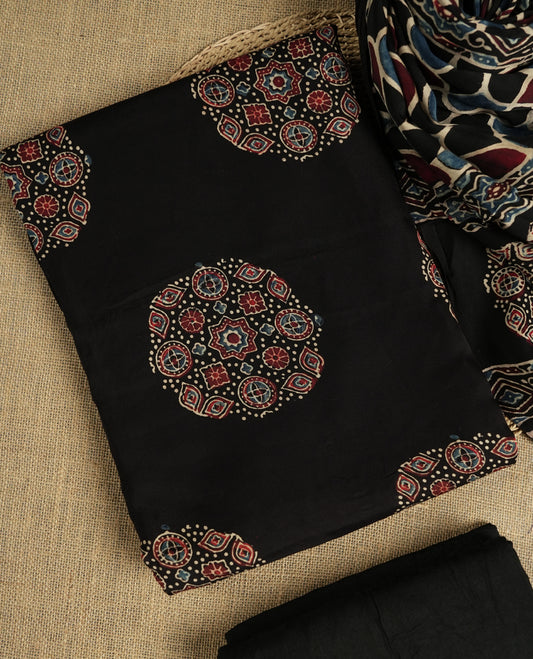 Black suit material featuring intricate Ajrak inspired prints in maroon, blue, and beige & Includes a beautifully patterned dupatta and matching plain bottom.