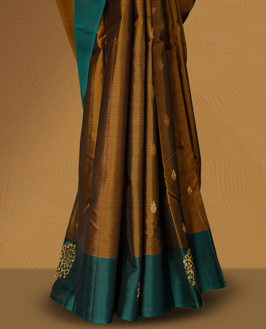 Coffee brown colour soft silk saree adorned with intricate golden zari motifs, teal green colour border for a perfect blend of tradition & Paired with a matching blouse.