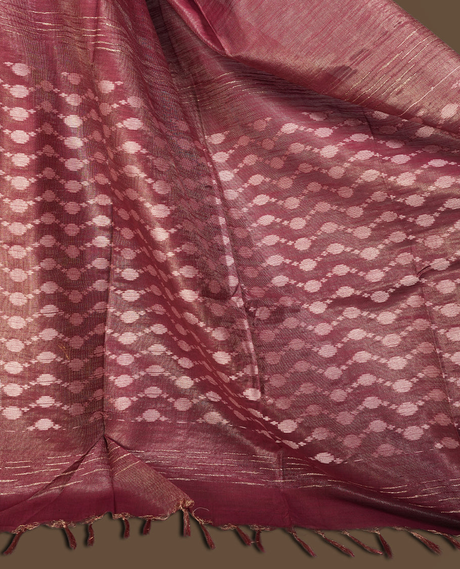 Burgundy brown colour semi jute tissue saree featuring delicate wave motifs on the body, complemented by a lustrous zari striped pallu and matching blouse piece for a refined festive look.