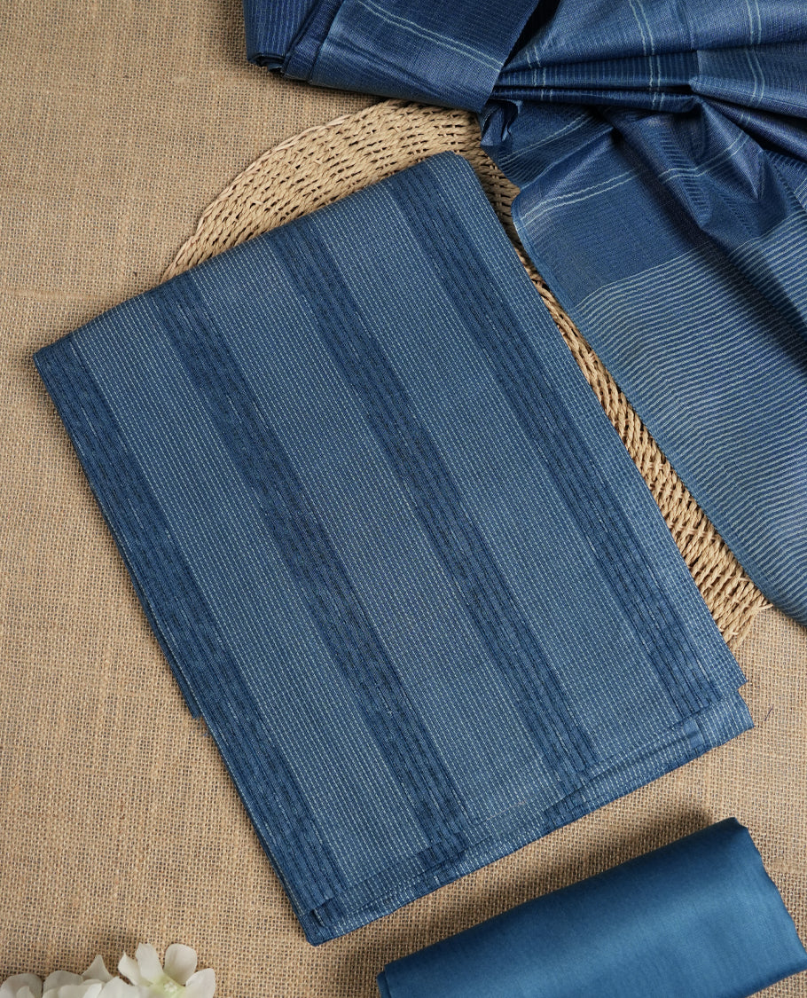 Denim blue colour tussar suit material featuring subtle striped patterns & Includes a soft dupatta with delicate tassels and matching plain fabric for the bottom.