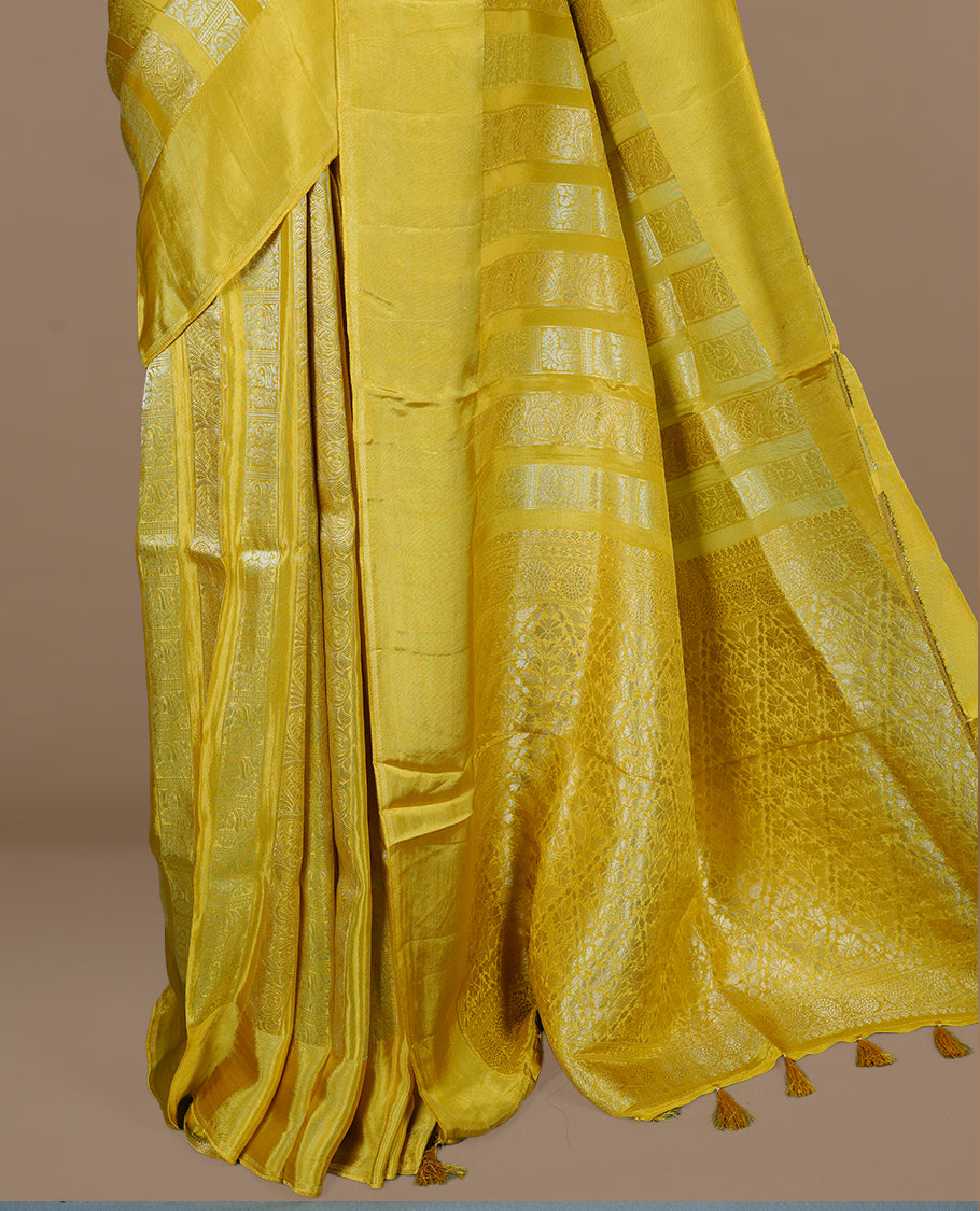 Yellow colour banaras crepe saree featuring gold & silver zari design stripes on body, complemented by self colour border, paired with matching blouse piece.