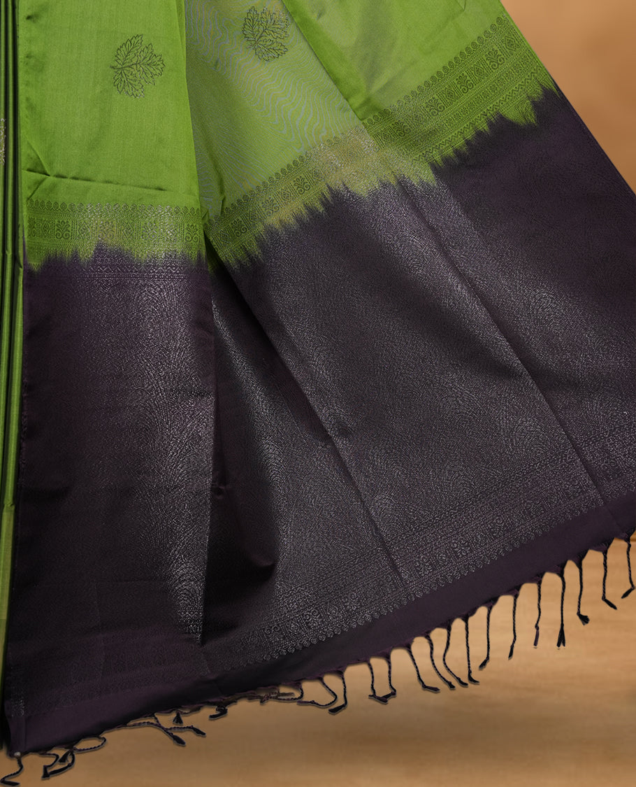 Olive green colour soft silk saree featuring Antique zari motifs on body with Highlighting contrast Navy blue colour pallu and paired with matching blouse piece.