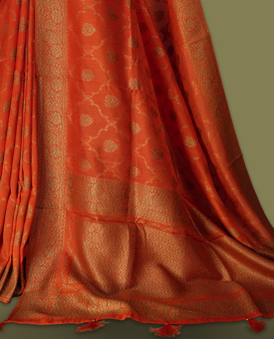 Orange colour semi Banarasi Tussar Georgette saree with gold zari motifs on the body, a grand woven golden pallu, and ornate zari border. Includes a matching blouse piece for a complete look.