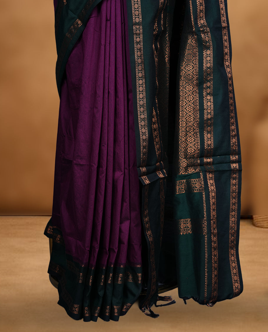 Purple colour mixed Kalyani cotton saree with subtle zari motifs, dark green zari border and rich traditional pallu, paired with a matching blouse.