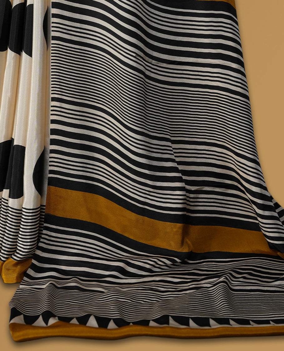 Cream colour saree with bold black polka dots, fine striped design, and mustard yellow borders & Paired with a matching blouse.